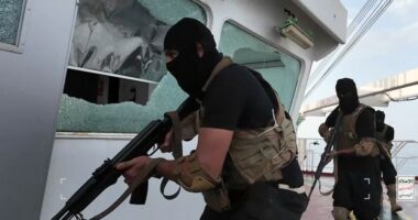 Armed men in black tactical gear aboard a ship.