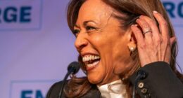 Kamala Harris laughing at a podium.