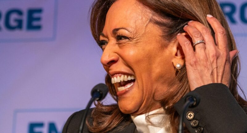 Kamala Harris laughing at a podium.