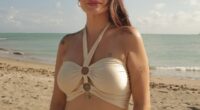 Woman on a beach in a beige halter top and matching skirt.