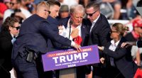 Donald Trump being helped off stage at a campaign event.