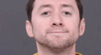 Mugshot of a man in a yellow shirt.