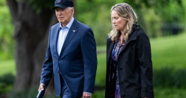 President Biden and a staff member walking on the White House South Lawn.