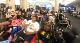 Large group of travelers waiting at LAX airport for a Honolulu flight.