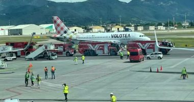 A Volotea airplane on a tarmac surrounded by emergency vehicles.
