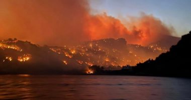 Homes in Crete burning in a wildfire at night.