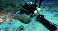Diver exploring an underwater shipwreck site.