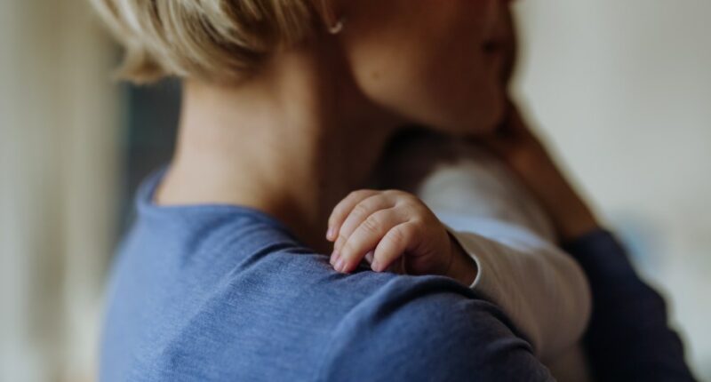 Close-up of a mother cuddling her baby.