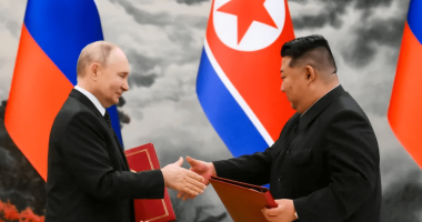 Vladimir Putin and Kim Jong-un shaking hands.