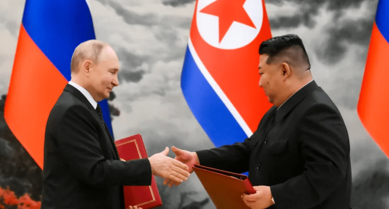 Vladimir Putin and Kim Jong-un shaking hands.