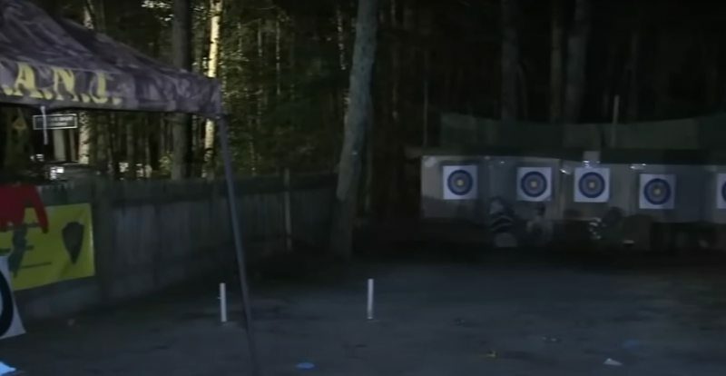 Nighttime photo of an archery range with targets and people.
