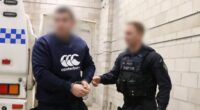 An alleged Rebels bikie member has been charged after police uncovered a video of a caged cat being fatally shot at point-blank range on his phone.