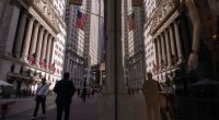 A reflection of a window shows the New York Stock Exchange