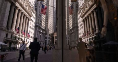 A reflection of a window shows the New York Stock Exchange