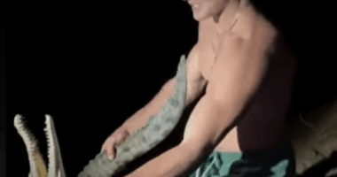 Man wrestling a crocodile.