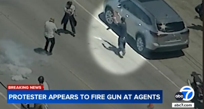 Video still of a protestor appearing to fire a gun at agents.