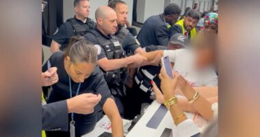 Airport security subdues a disruptive passenger.