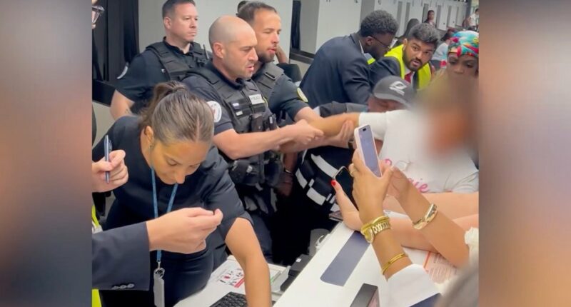 Airport security subdues a disruptive passenger.