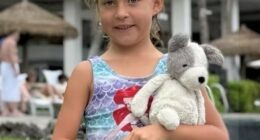 Girl holding a stuffed dog.
