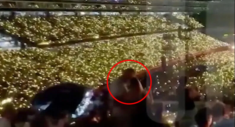 Stadium crowd holding up lights.