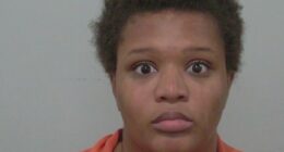 Mugshot of a young woman in an orange jumpsuit.