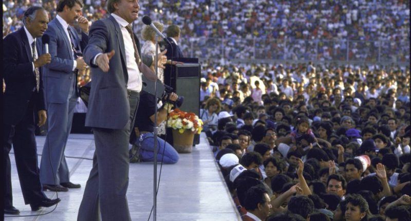 Jimmy Swaggart preaching to a large crowd.