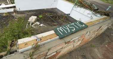 A Camp Mystic sign is seen near the entrance to the establishment along the banks of the Guadalupe River after a flash flood swept through the area in Hunt, Texas, Saturday, July 5, 2025. (AP Photo/Julio Cortez)