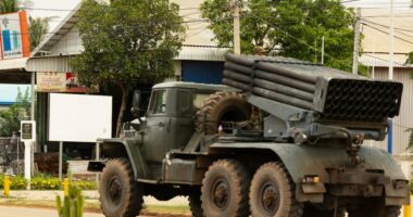 Cambodian military truck with rocket launcher driving away.