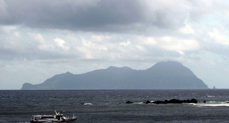 Akuseki Island, Japan, viewed from the sea with a boat.