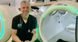 Therapist sitting in front of hyperbaric chambers.