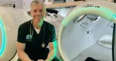 Therapist sitting in front of hyperbaric chambers.