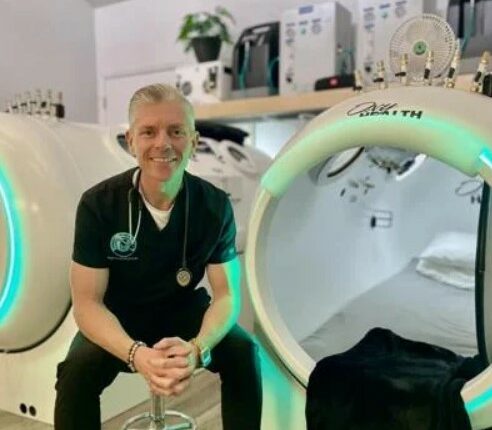 Therapist sitting in front of hyperbaric chambers.