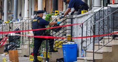 Crime scene investigators collecting evidence at a shooting scene.