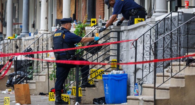 Crime scene investigators collecting evidence at a shooting scene.