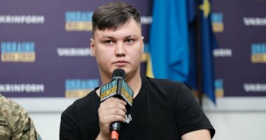 Man at press conference holding microphone.