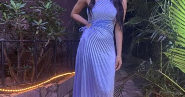 Woman in a light blue pleated dress.
