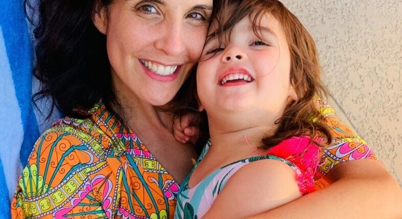 Photo of a mother hugging her young daughter.