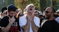 A grieving father mourns at his son's funeral.