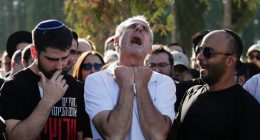 A grieving father mourns at his son's funeral.