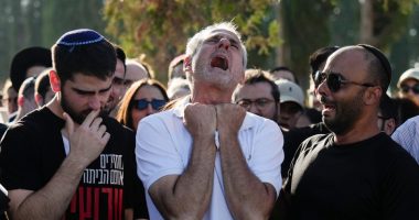 A grieving father mourns at his son's funeral.
