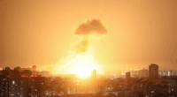 Large explosion over a city at night.