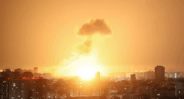 Large explosion over a city at night.