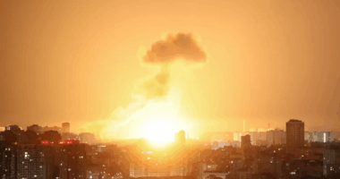 Large explosion over a city at night.