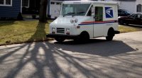 US Post Office truck parked on a residential street.