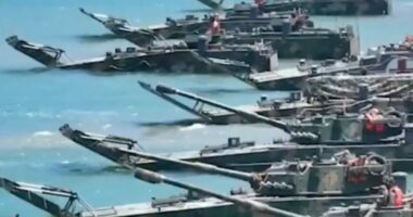 Military amphibious vehicles in the water.