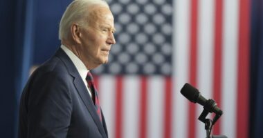 Biden speaks at a podium in front of a US flag