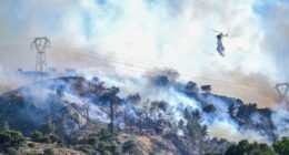 Helicopter dropping water on a wildfire.