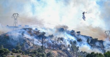 Helicopter dropping water on a wildfire.