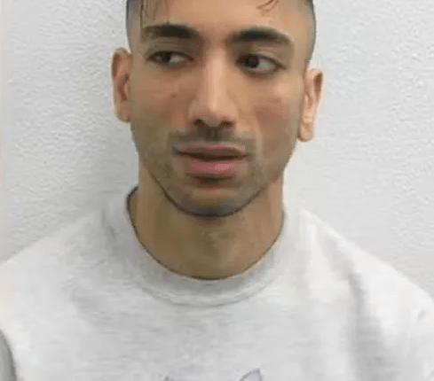 Man with unique hairstyle wearing a sweatshirt with three kittens printed on it.