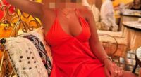 Woman in orange dress with face blurred.
